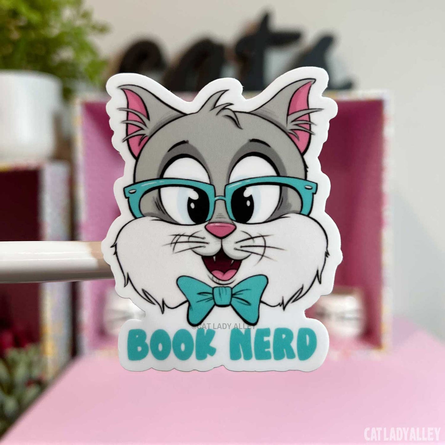 illustrated sticker of gray cat with book nerd text