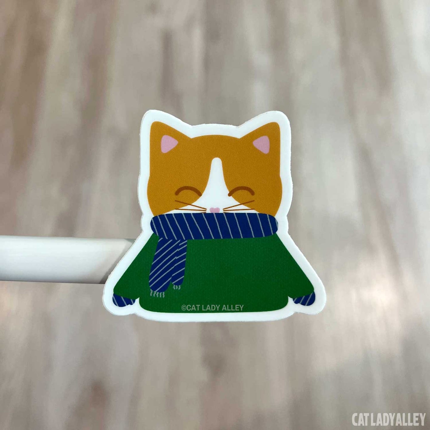 orange and white cat in sweater sticker